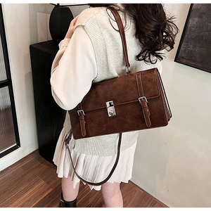 Detail of vintage brown messenger bag with silver square lock and adjustable shoulder strap