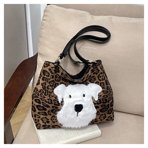 Detailed shot of leopard print tote bag with white plush dog patch and leather handles