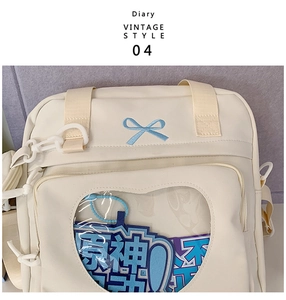 Detail of canvas bag featuring blue bow embroidery and heart-shaped transparent window