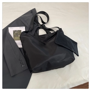 Macro detail of waterproof black nylon tote bag with a small matching mesh zipper pouch