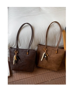 Detail of vintage tote bags in coffee and brown with bead charms and soft texture