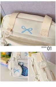 Detail of beige canvas crossbody bag with light blue bow embroidery and round pouch