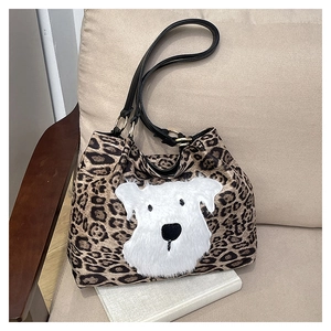 Close-up of leopard print tote bag with plush dog patch and gold metal ring detail