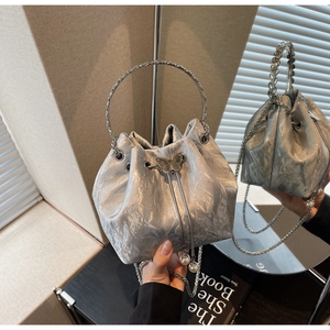 Détails du sac seau métallisé argenté avec pendentif papillon et accent en perles