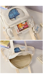 Detail of cream canvas ita bag featuring a large clear window for displaying badges