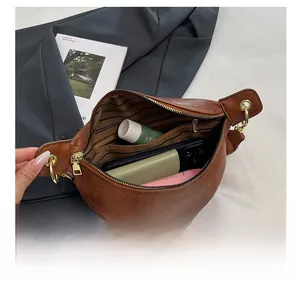 Detail view of vintage brown crossbody bag interior showing zip pocket and large capacity