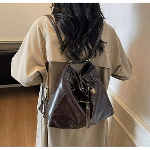 Detailed view of the dark brown leather texture and brass hardware on a large tote bag