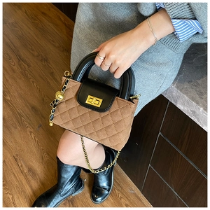 Detail of vintage quilted chain bag with gold twist lock and dual-color leather design