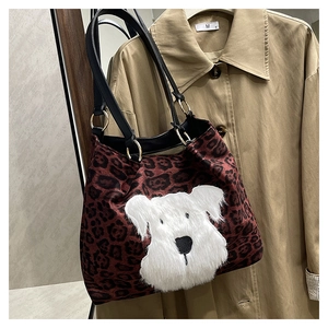 Detail of leopard print tote bag with 3D plush dog patch and black shoulder straps
