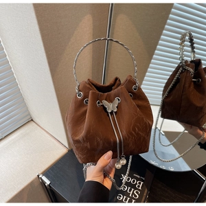 Détail d'un sac seau marron à cordon avec poignée anneau argentée et breloques en perles