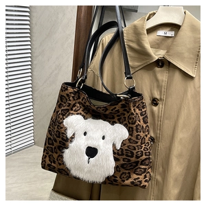 Detailed close-up of leopard print tote bag featuring a cute plush dog patch and leather straps