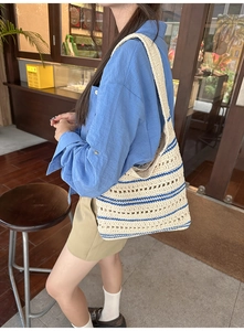 Detail view of woven bucket bag featuring cream and blue stripes with hollow knit texture