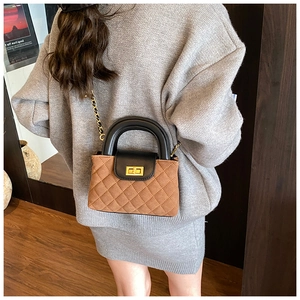 Detail of a quilted crossbody bag with brown and black contrast and golden twist lock