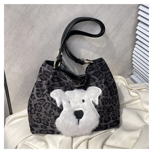 Close-up of leopard print canvas tote bag with a white plush dog applique and gold ring