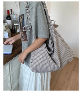 Detail of checkered canvas tote bag featuring ruffled shoulder straps and bow knot detail