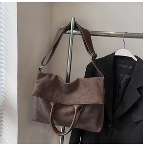 Detail of vintage brown suede tote bag featuring a wide adjustable strap and large capacity