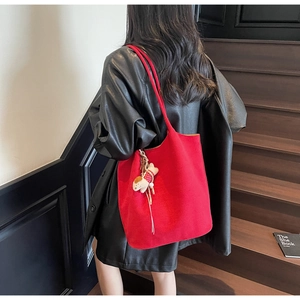 Large red tote bag in thick felt texture with a cute puppy charm on a black leather jacket