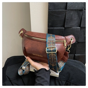 Dettaglio borsa a mezzaluna marrone vintage con tracolla ricamata e finiture oro