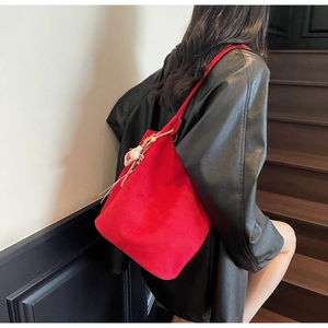 Detail view of large red tote bag showing textured material and small pendant detail