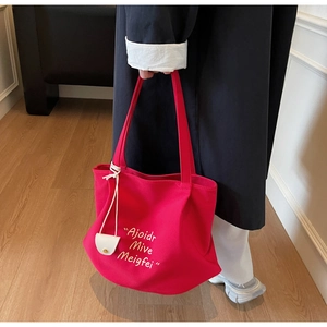 Close-up of bright magenta canvas tote bag with white minimalist letter printing