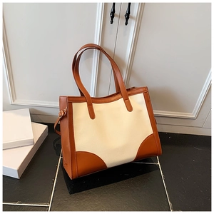 Détail du sac cabas bicolore en toile crème et finitions en cuir marron élégant