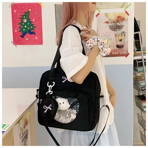 Close-up of black canvas cross-body bag with clear window and purple bow embroidery