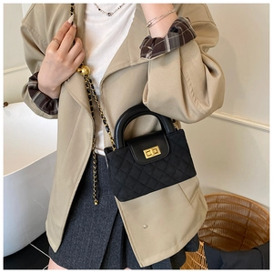 Detail shot of the black quilted crossbody bag with gold chain and metal twist lock