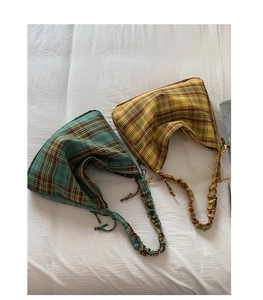 Detailed overhead shot of plaid canvas tote bags with pleated straps in green and yellow