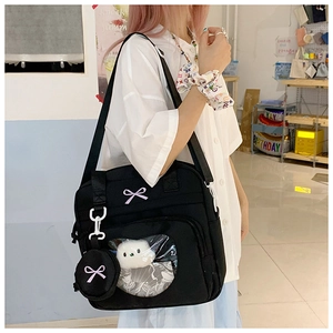 Detail of black tote bag with heart-shaped transparent window and purple bow accents