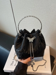 Sac seau noir texturé élégant avec fermoir papillon argenté et détail perle