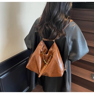 Brown vintage leather backpack featuring a unique triangular folding design and gold hardware