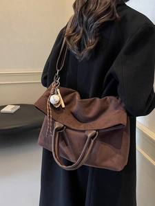 Vintage dark brown suede tote bag with baseball charms shown in a casual lifestyle setting