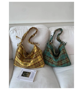 Close-up of vintage plaid tote bags in yellow and green with pleated shoulder straps
