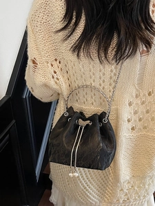 Sac seau plissé noir élégant avec poignée anneau argentée et breloque papillon perle