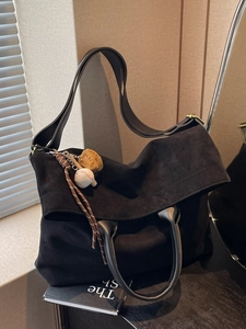 Black large capacity vintage tote bag with baseball pendant charm in soft lighting