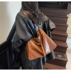 Brown leather tote bag featuring a vintage silhouette and fine hardware on a model