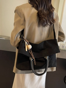Retro black canvas tote bag with baseball pendants and leather handles on model