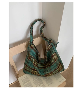 Detail of green plaid hobo bag featuring a scrunchie strap and retro checkered design