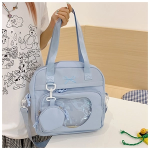 Macro detail of light blue tote bag with heart clear window and bow embroidery