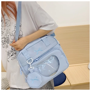 Detail of light blue ita bag with transparent window and bow embroidery detail