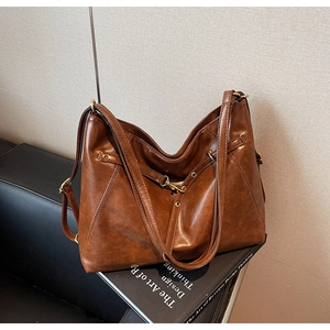 Close-up of vintage dark brown tote bag with adjustable strap and metal hardware detail