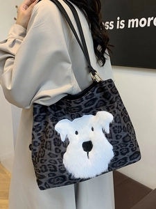Leopard print tote bag with plush dog patch and long black shoulder straps shown on model