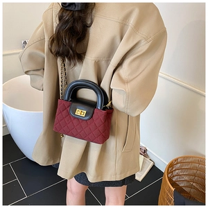 Detailed view of wine red quilted mini bag with gold-tone hardware and chain strap