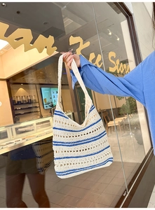 Detail of blue striped crochet shoulder bag with intricate hollow-out knit texture