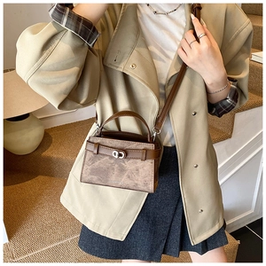 Detailed view of the vintage brown crossbody bucket bag with metallic twist lock and texture