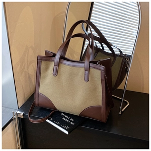 Détail du grand sac cabas en toile avec renforts en cuir marron et anses robustes