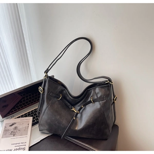 Detail of oil-wax texture tote bag with bronze metal rings and vintage strap buckles