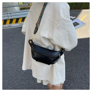 Dettaglio borsa a mezzaluna in pelle nera con tracolla larga a motivo vintage