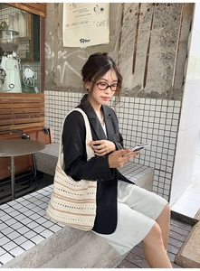 Chic hollow crochet woven shoulder bag with brown stripes in a cafe lifestyle setting
