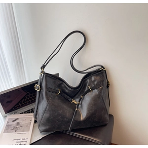 Detail of black large capacity shoulder bag with gold hardware and adjustable strap